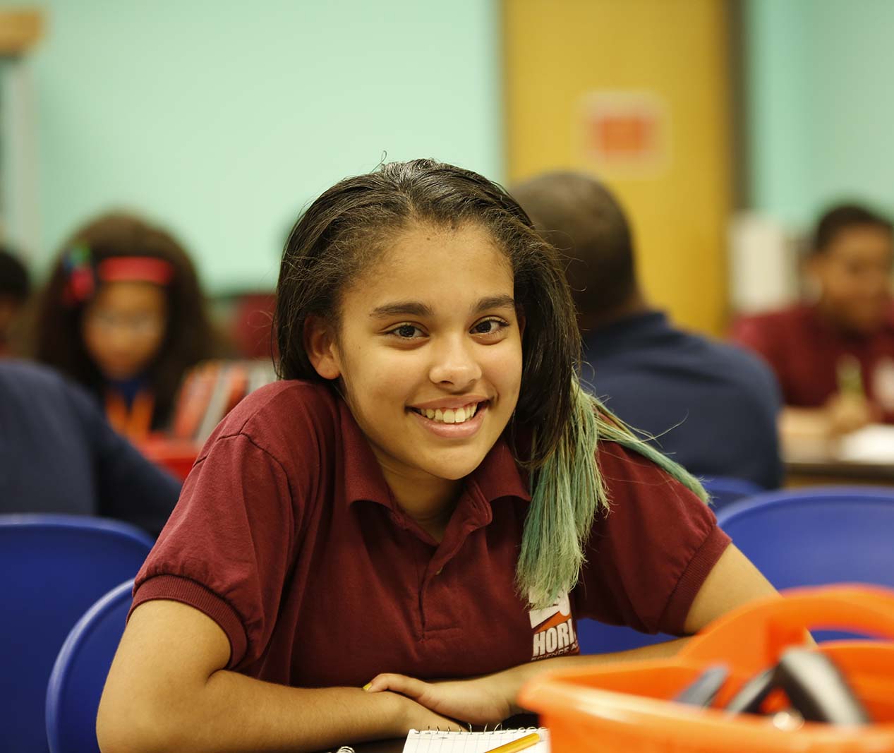 Student working on a notebook in a classroom.